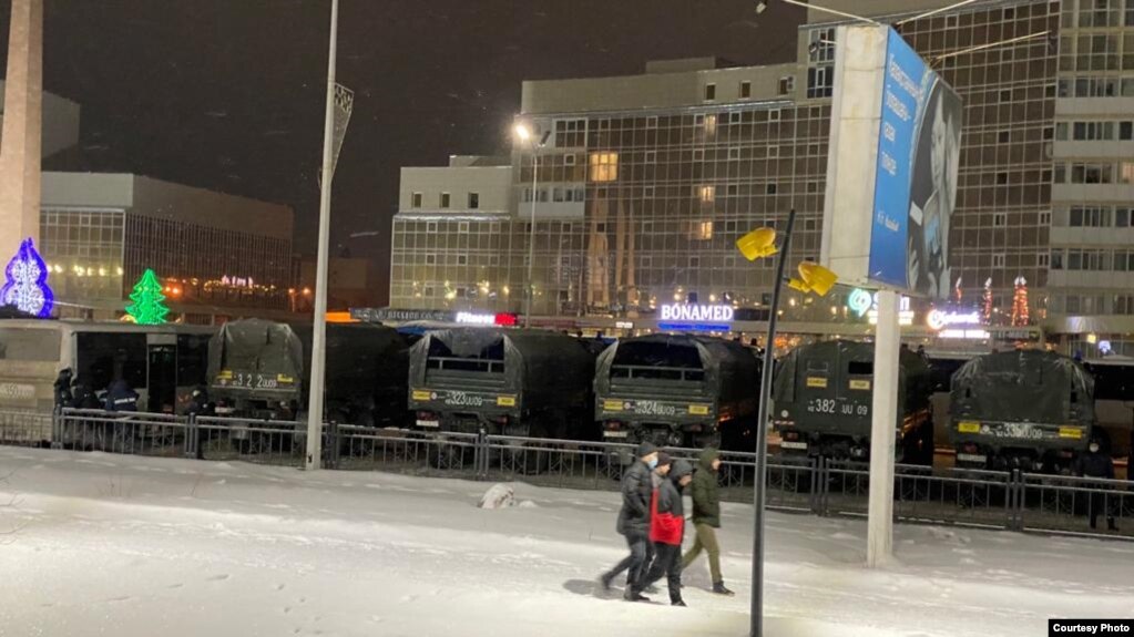 Полицейские и грузовики Нацгвардии МВД на улице в Караганде, где стоят митингующие. 4 января 2022 года rtikiqreiqdkkmp